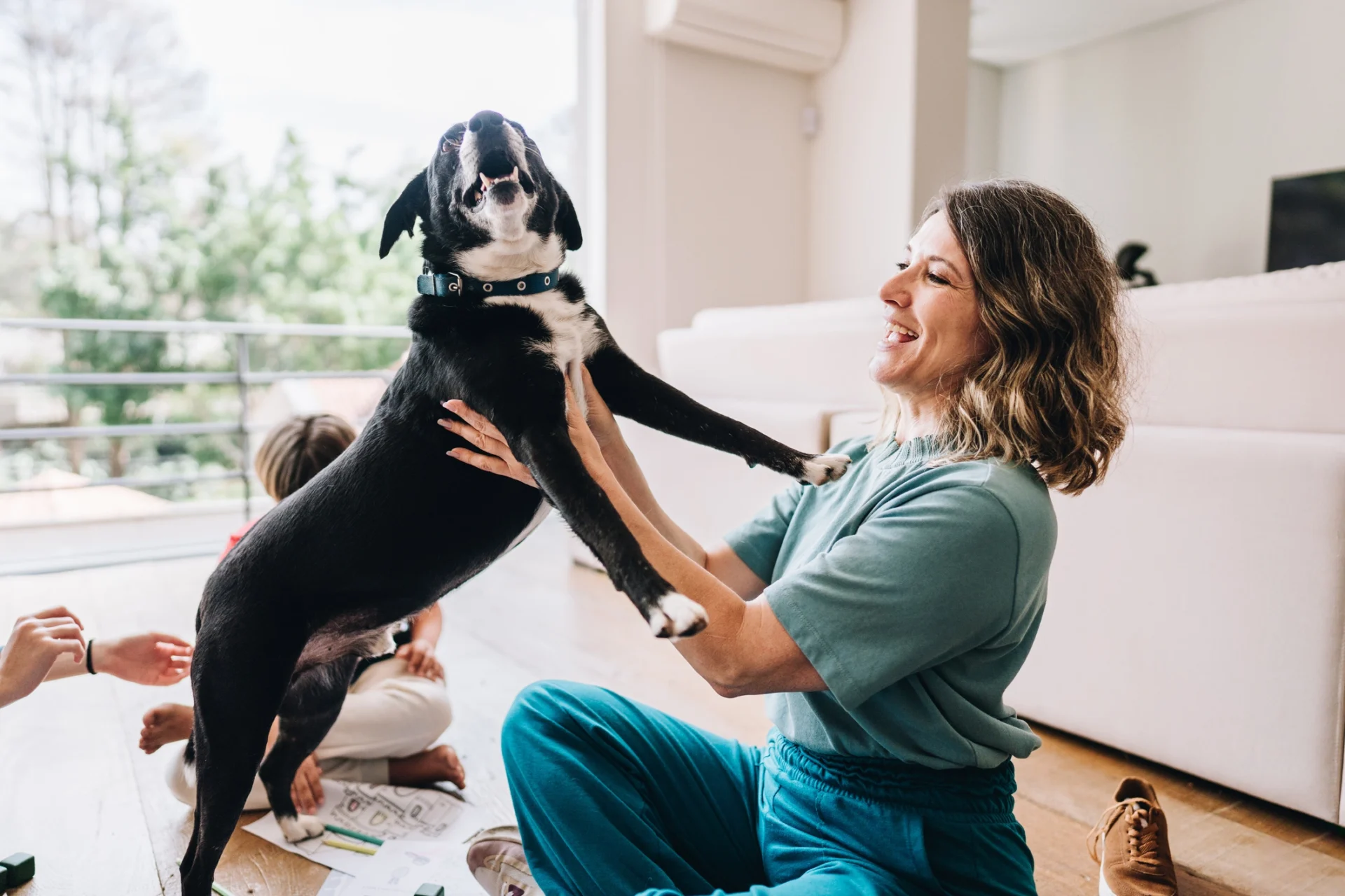 Woman playing with dog indoors